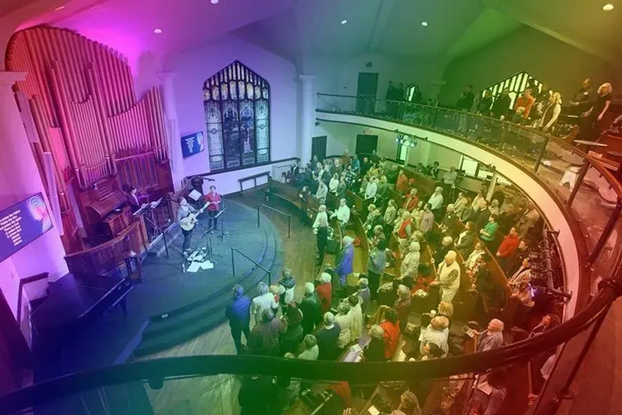 A large group of people are sitting in an auditorium watching a concert.