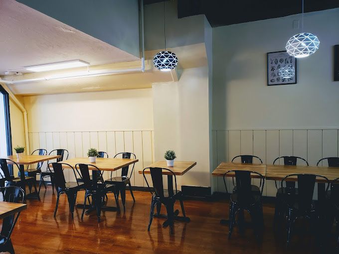 A restaurant with tables and chairs and a clock on the wall.