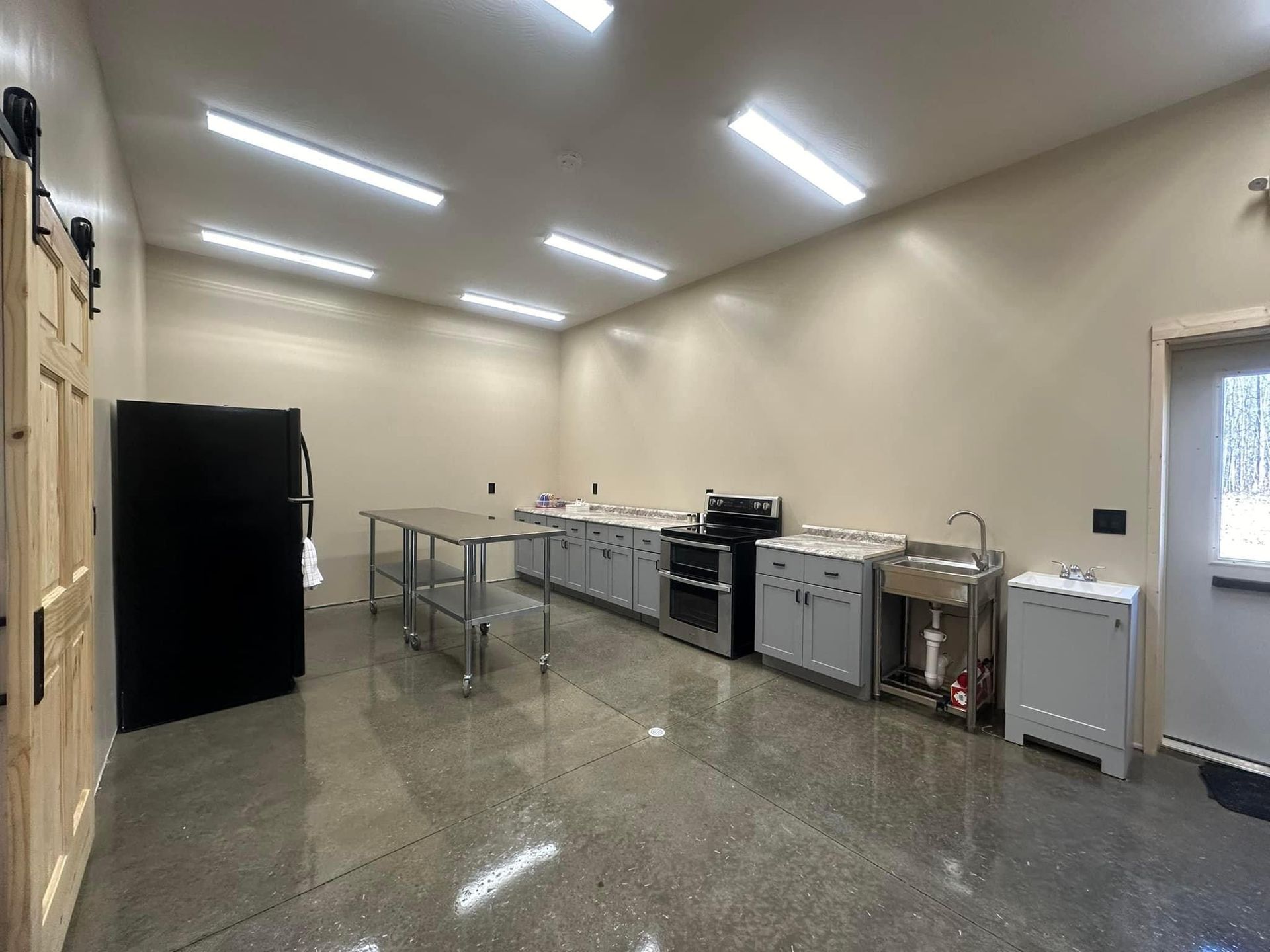 A large kitchen with stainless steel appliances and a refrigerator.