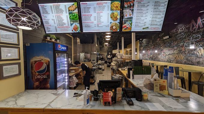 A restaurant with a pepsi refrigerator and a counter.