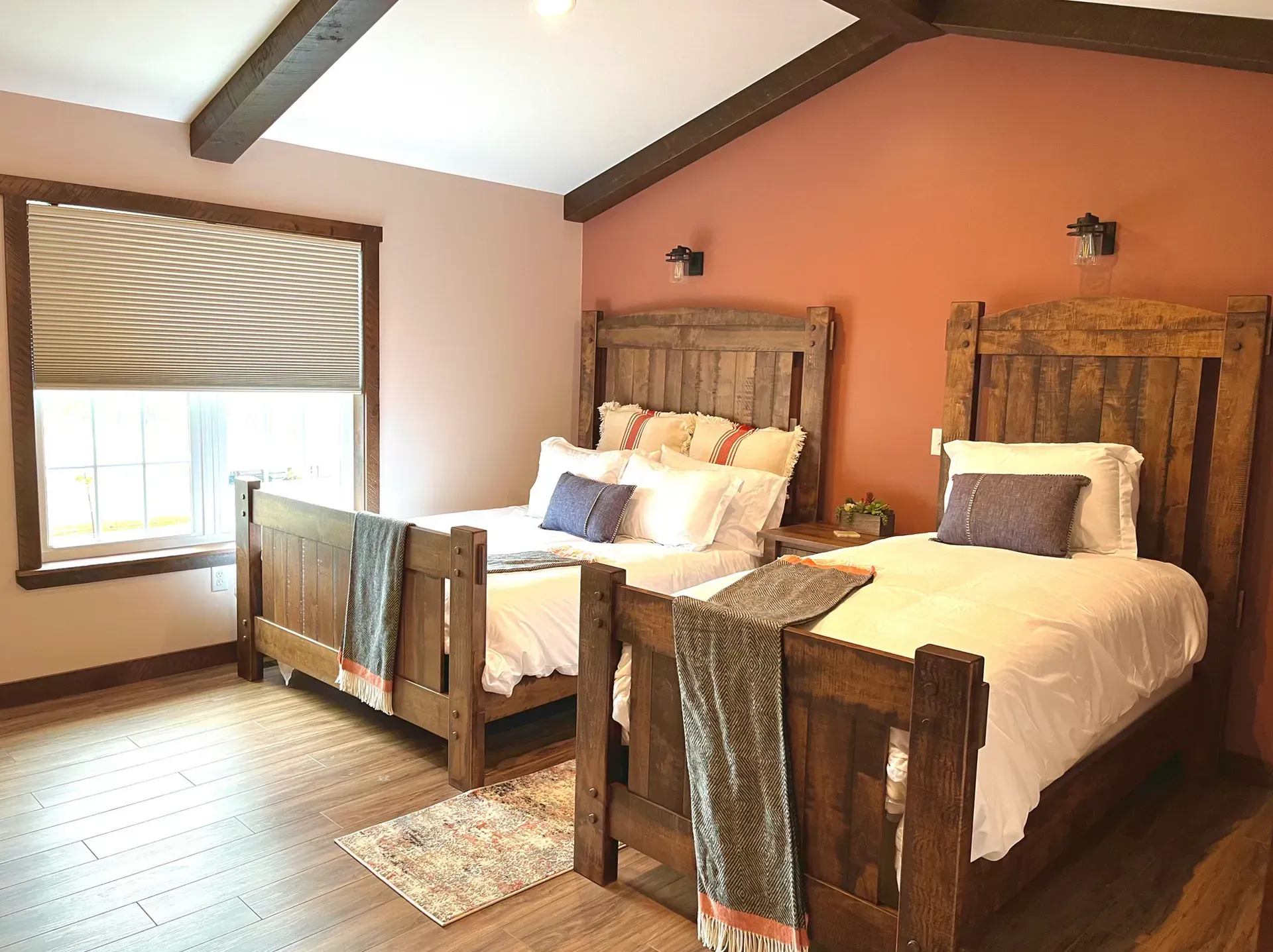 A bedroom with two beds and a window.