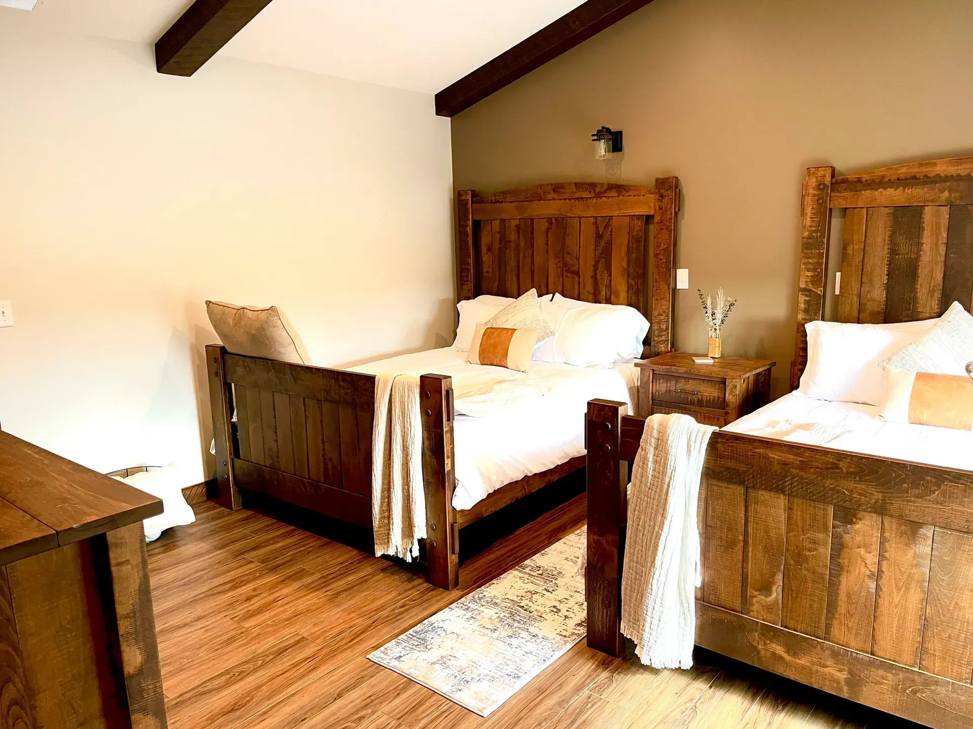 A bedroom with two beds and a dresser.