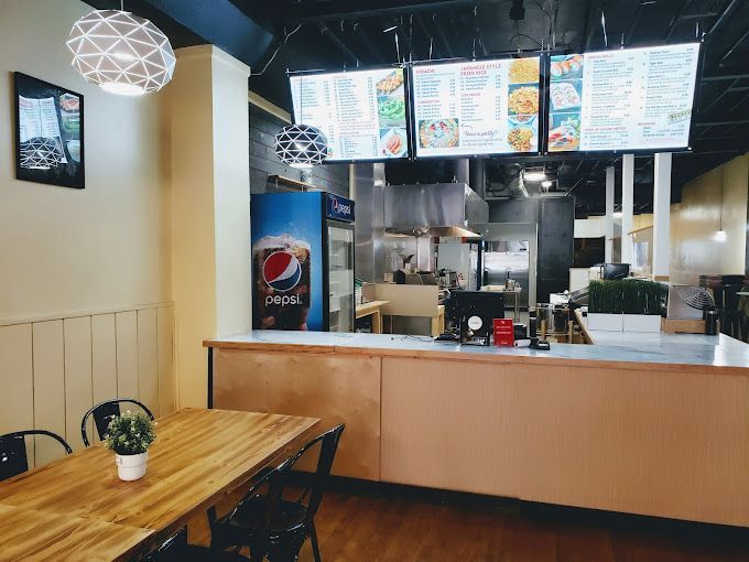 A restaurant with a table and chairs and a pepsi machine.