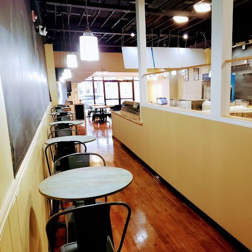 A long hallway with tables and chairs in a restaurant