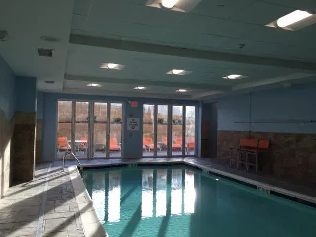 A large indoor swimming pool with a life preserver sign on the wall