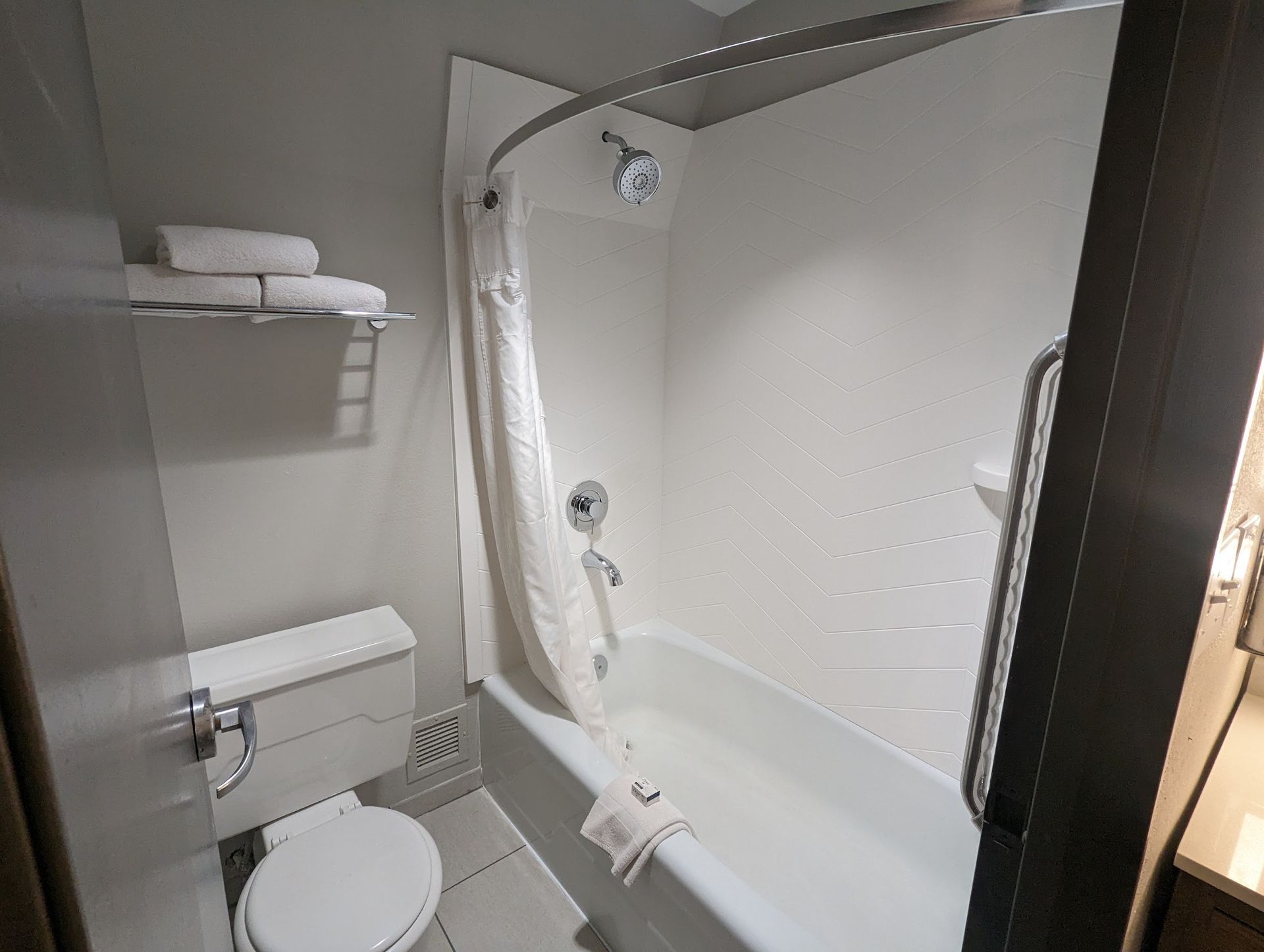 A bathroom with a toilet , bathtub and shower.