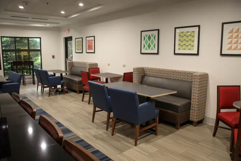 There are many tables and chairs in the room.