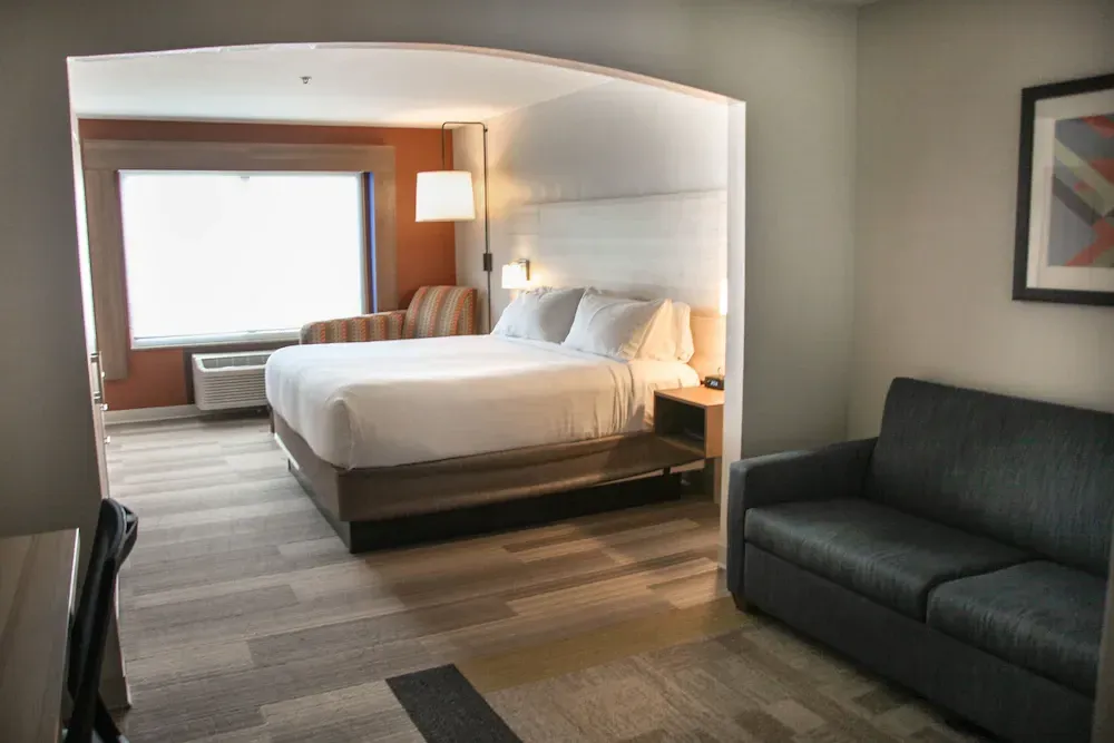 A hotel room with a king size bed and a couch.