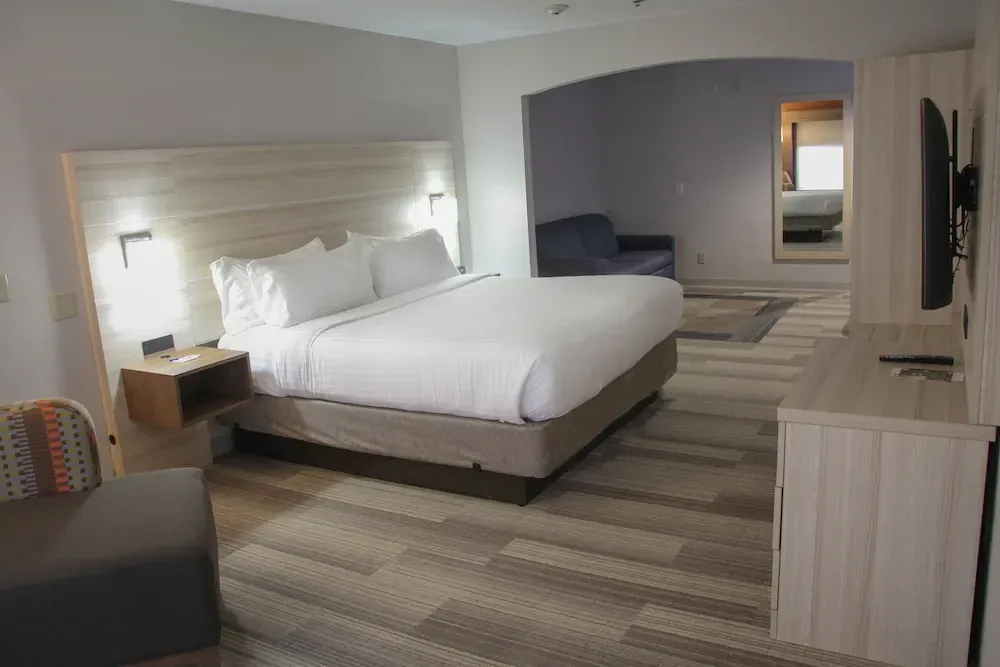 A hotel room with a king size bed and a couch.