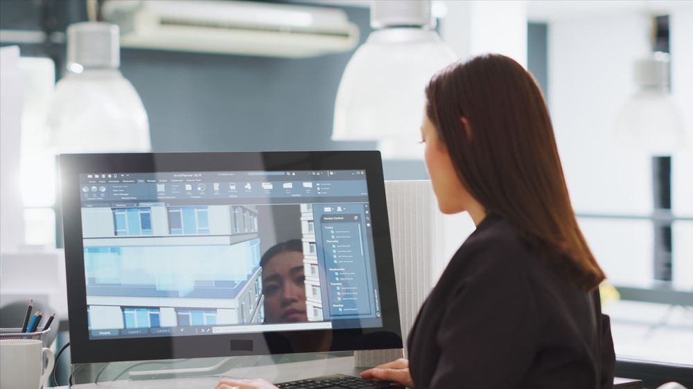 A woman is sitting at a desk using a computer.