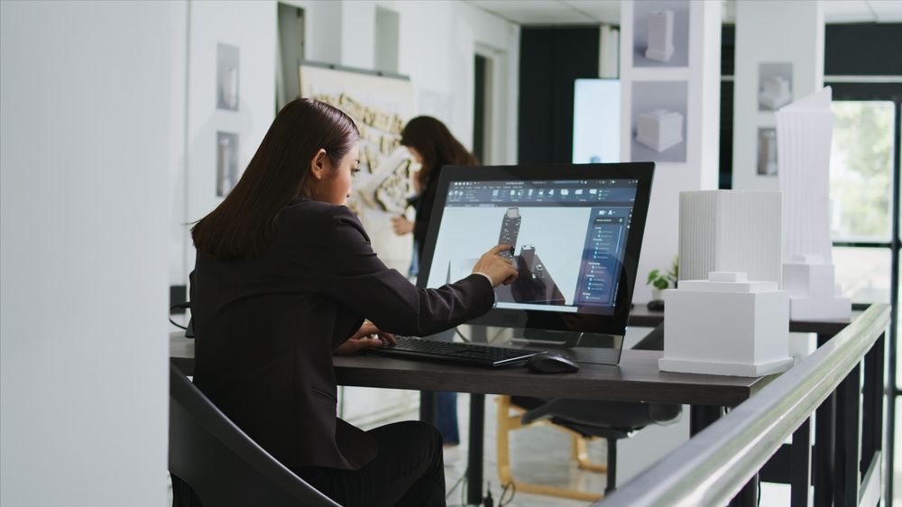 A woman is sitting at a desk using a computer.