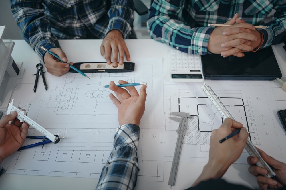 Team of engineers in a meeting, drawing blueprints for condo, apartment, and house construction.