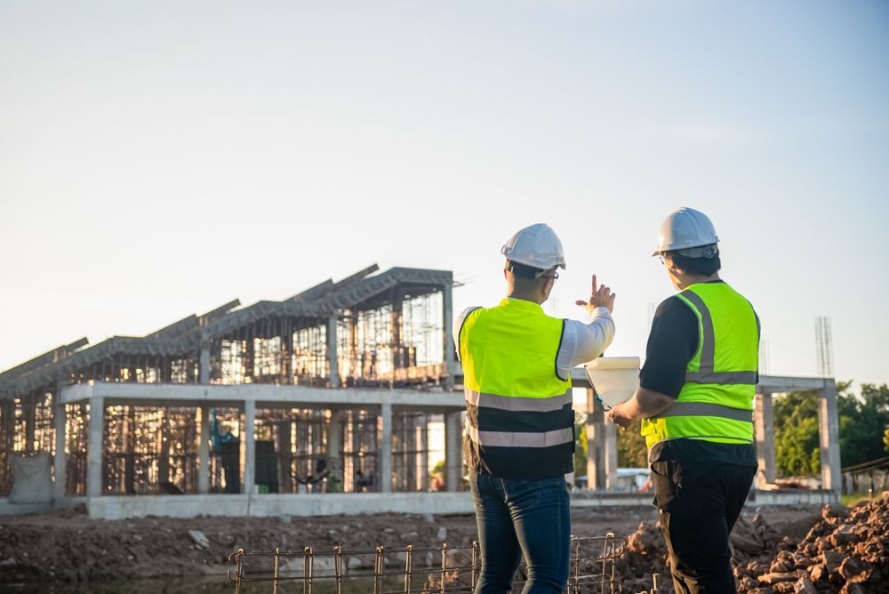 Two Architect man discussing about the building plan.