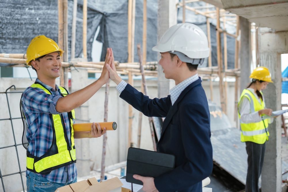 Two architects  are giving each other a high five.