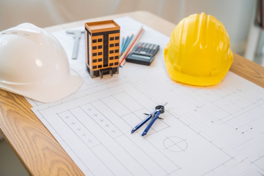 Architect's belonging are on a wooden table.