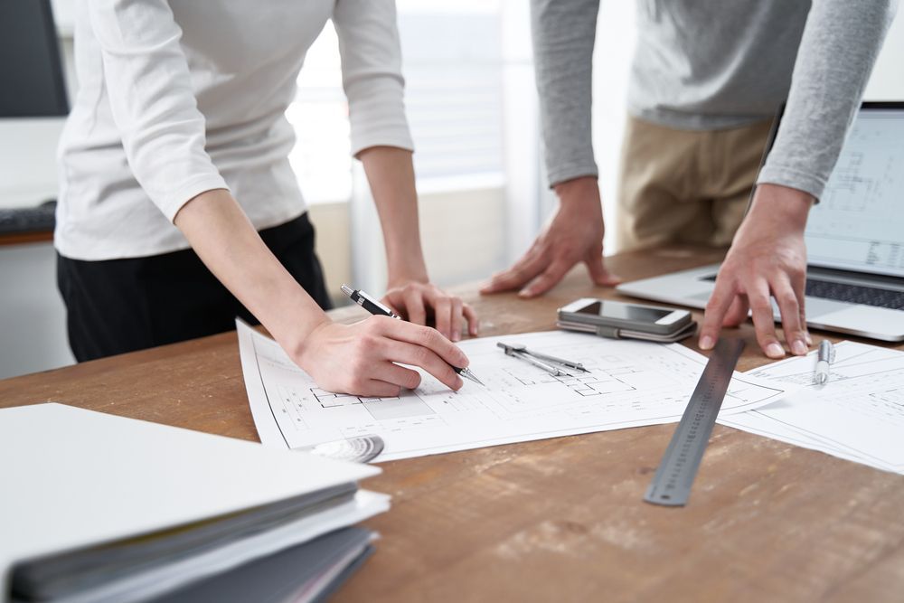 Two architects are working on the construction plans.