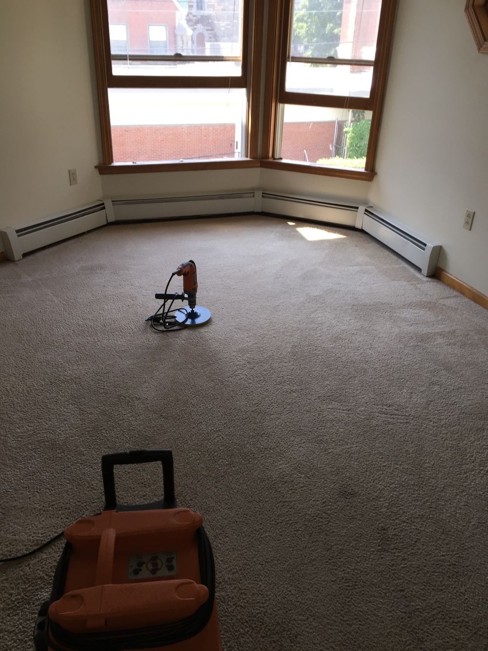 A vacuum cleaner is sitting on the floor in an empty room.