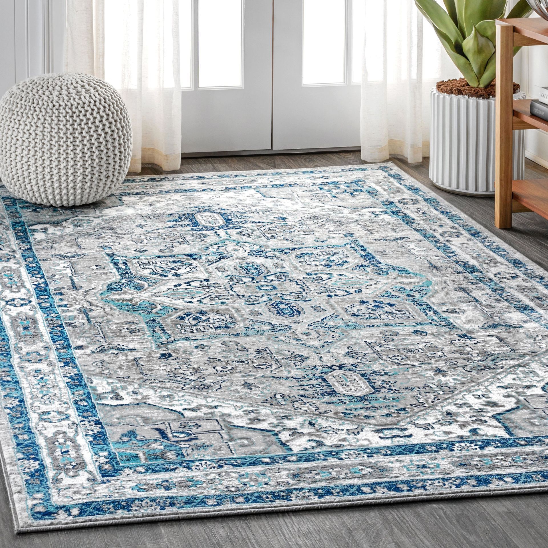 A blue and white rug is sitting on the floor in a living room.