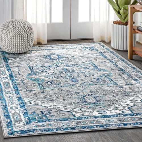 A blue and white rug is sitting on the floor in a living room.