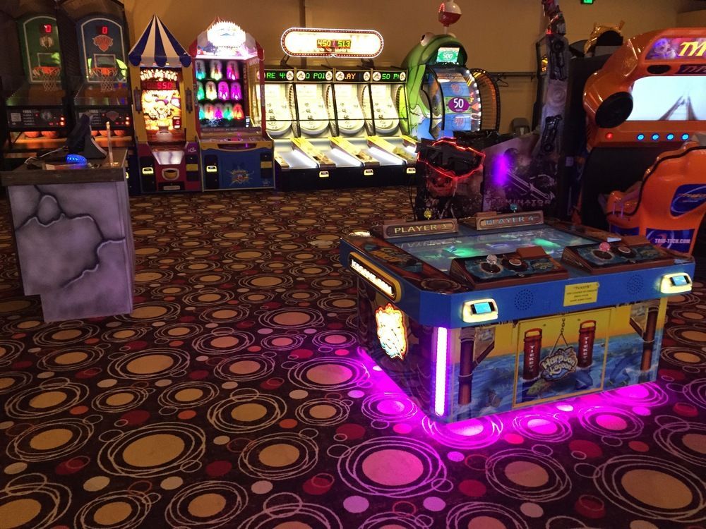A bunch of arcade games are lined up in a room