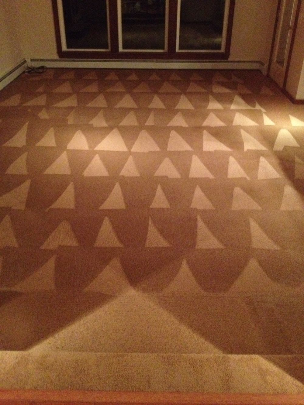 A carpeted floor with a pattern of triangles on it