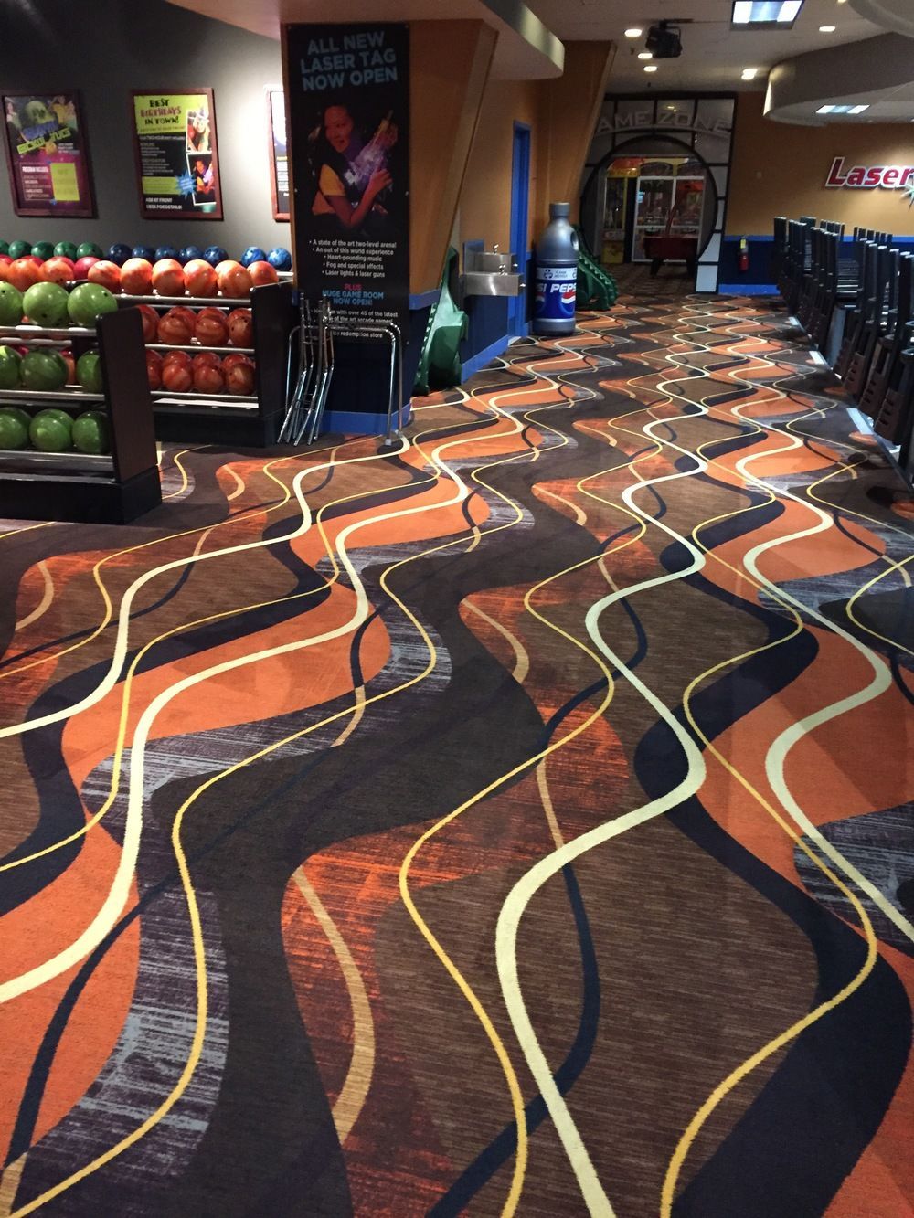 A bowling alley with a colorful carpet and bowling balls