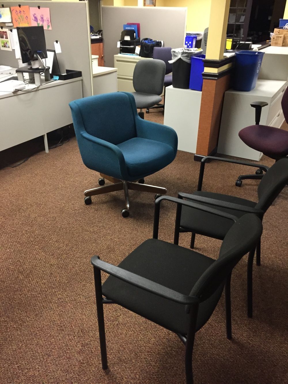 A blue chair sits in the middle of an office