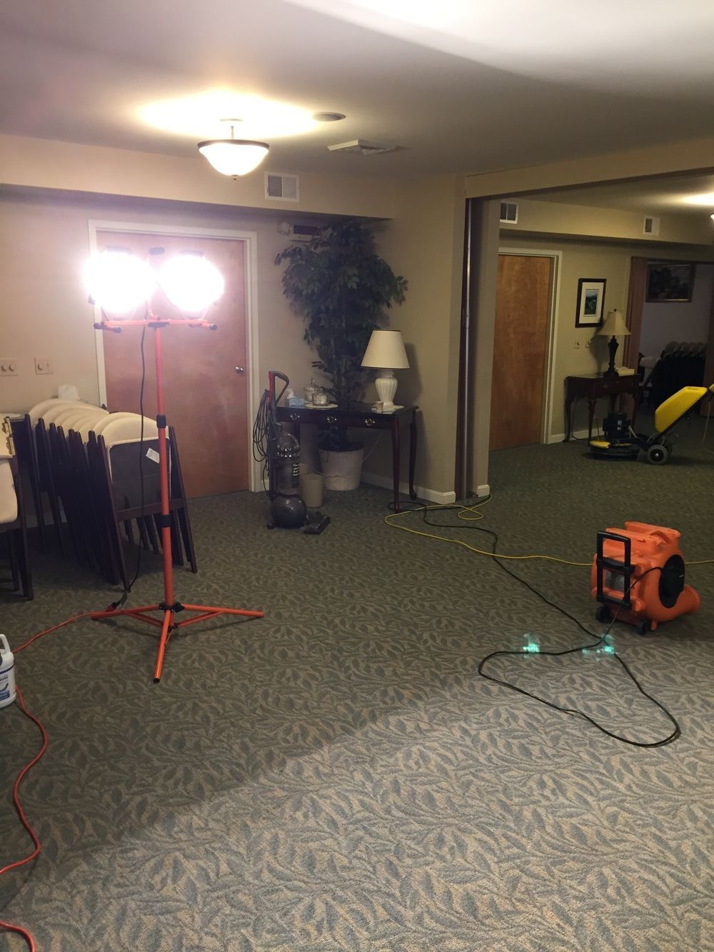 A large room with a lot of furniture and a vacuum cleaner in it.