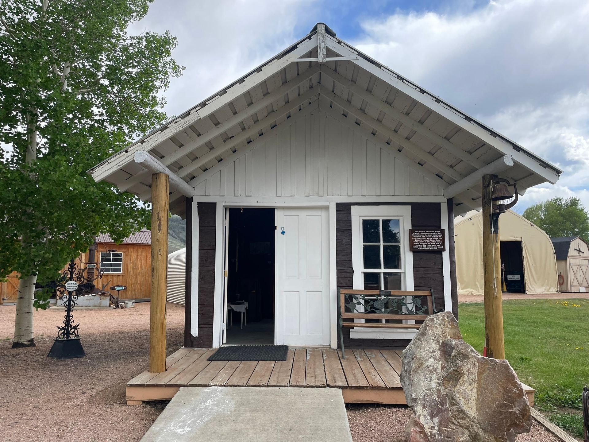 A small brown and white house with a white roof