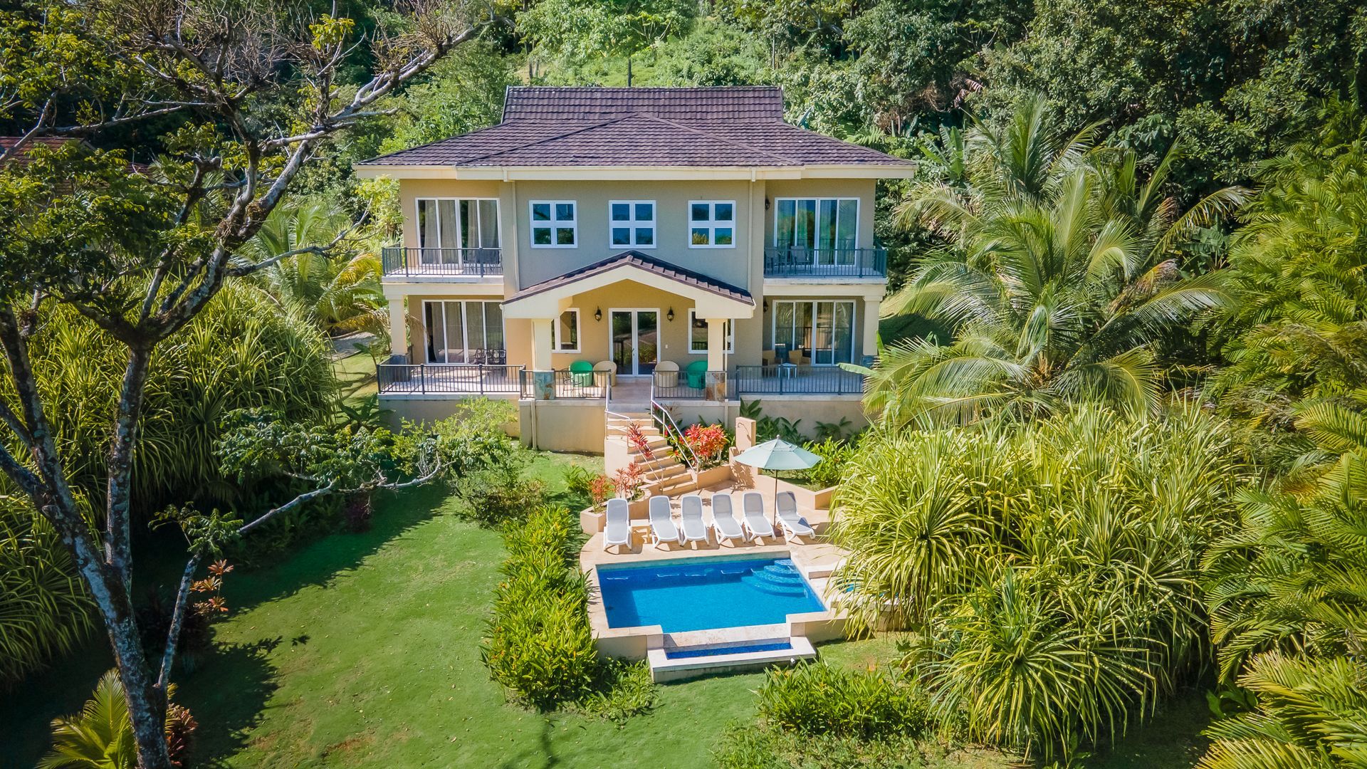 A large house with a swimming pool in front of it.