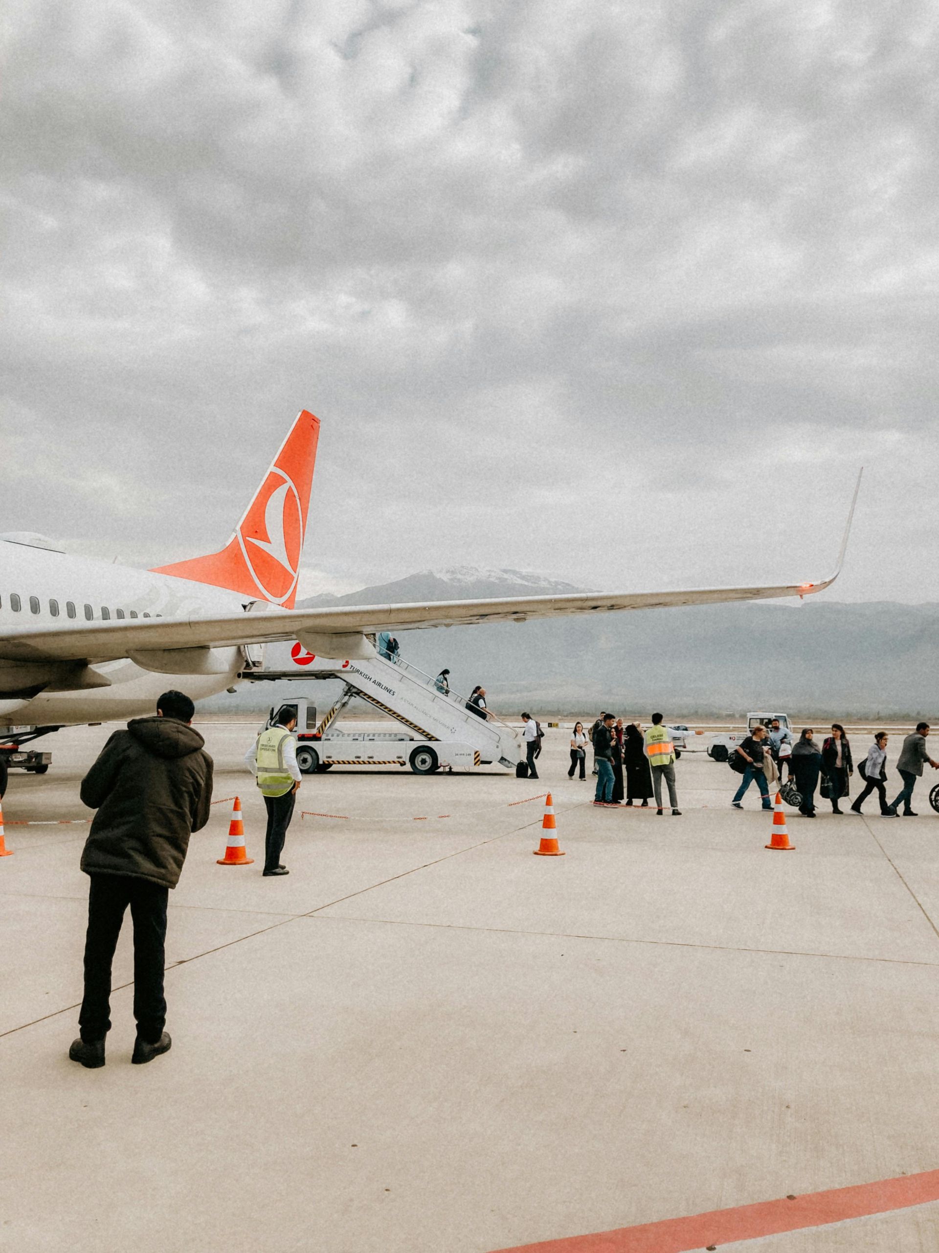 A group of people are boarding an airplane at an airport
