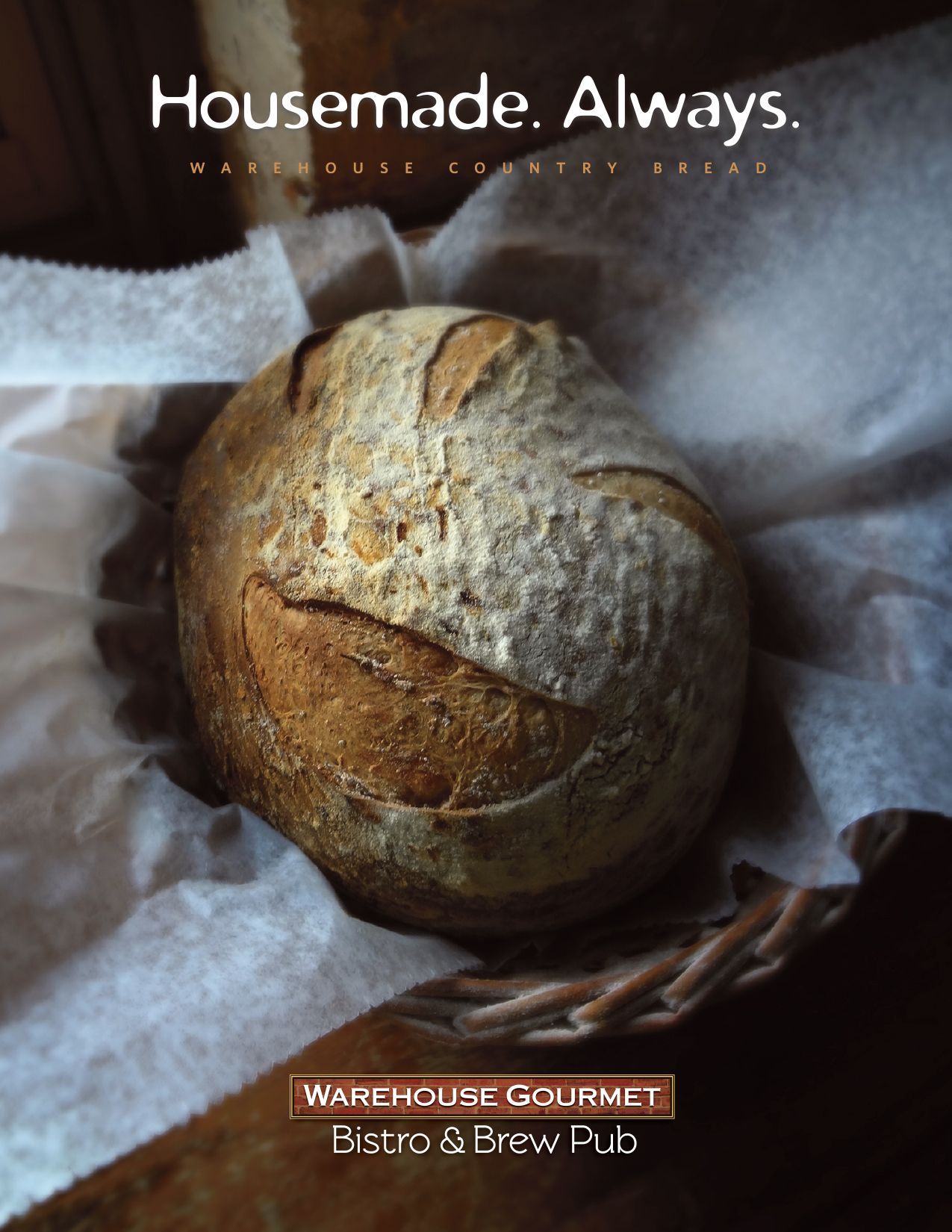 A round loaf of rustic, crusty bread sitting in a woven basket lined with white parchment paper.