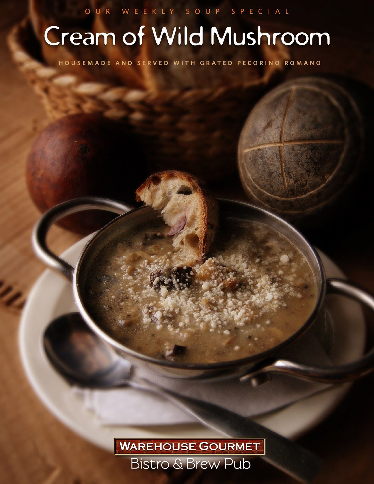 Cream of Wild Mushroom soup with grated cheese and bread in a metal bowl, from Warehouse Gourmet Bistro & Brew Pub.