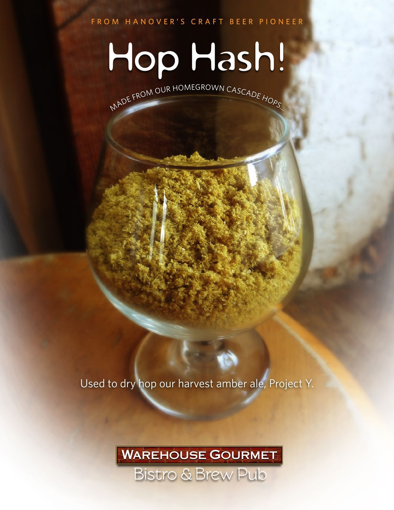 A glass snifter filled with yellow hop hash on a wooden table, with text promoting Warehouse Gourmet Bistro & Brew Pub.
