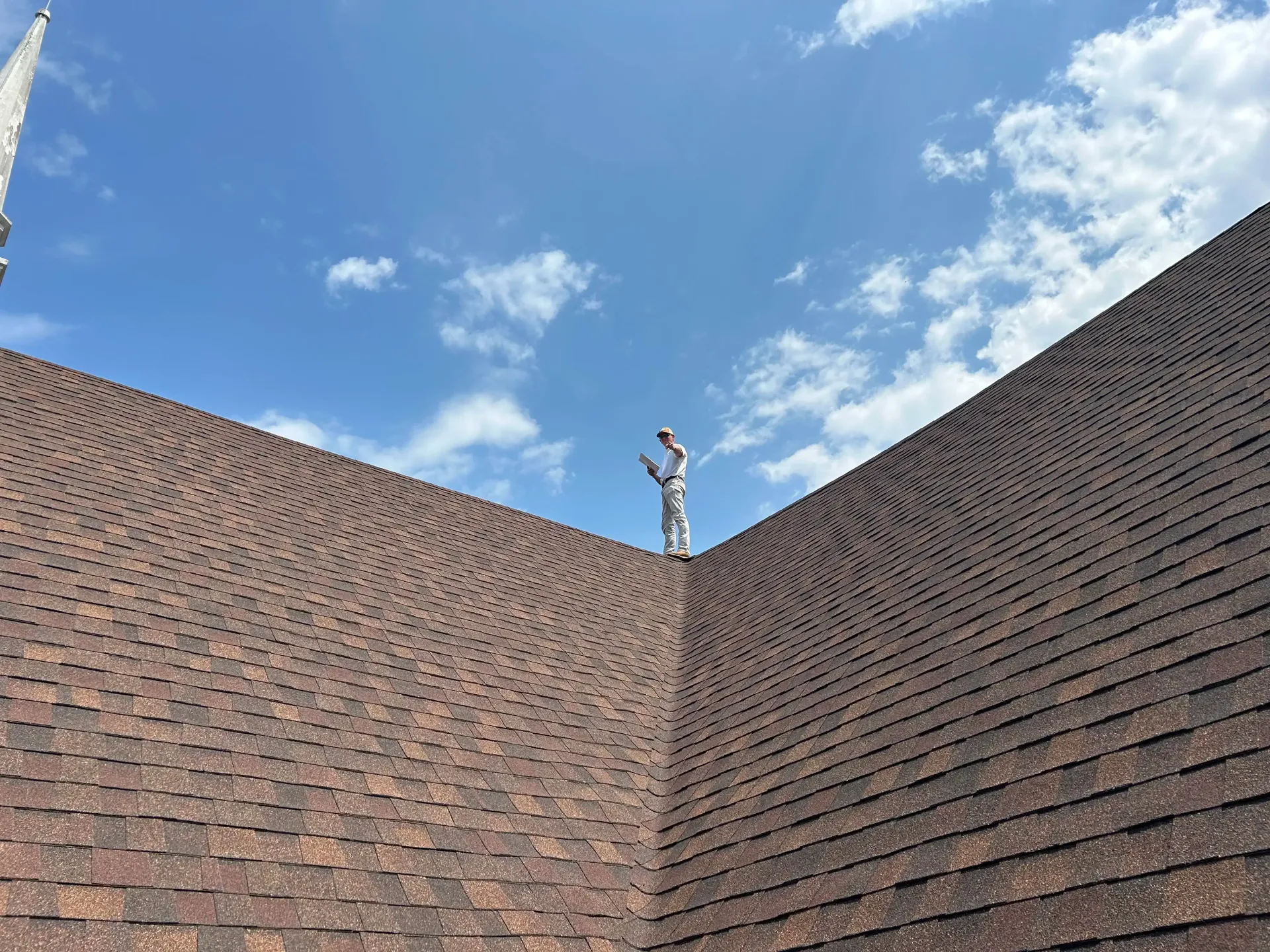 A statue of a man standing on top of a brick wall.