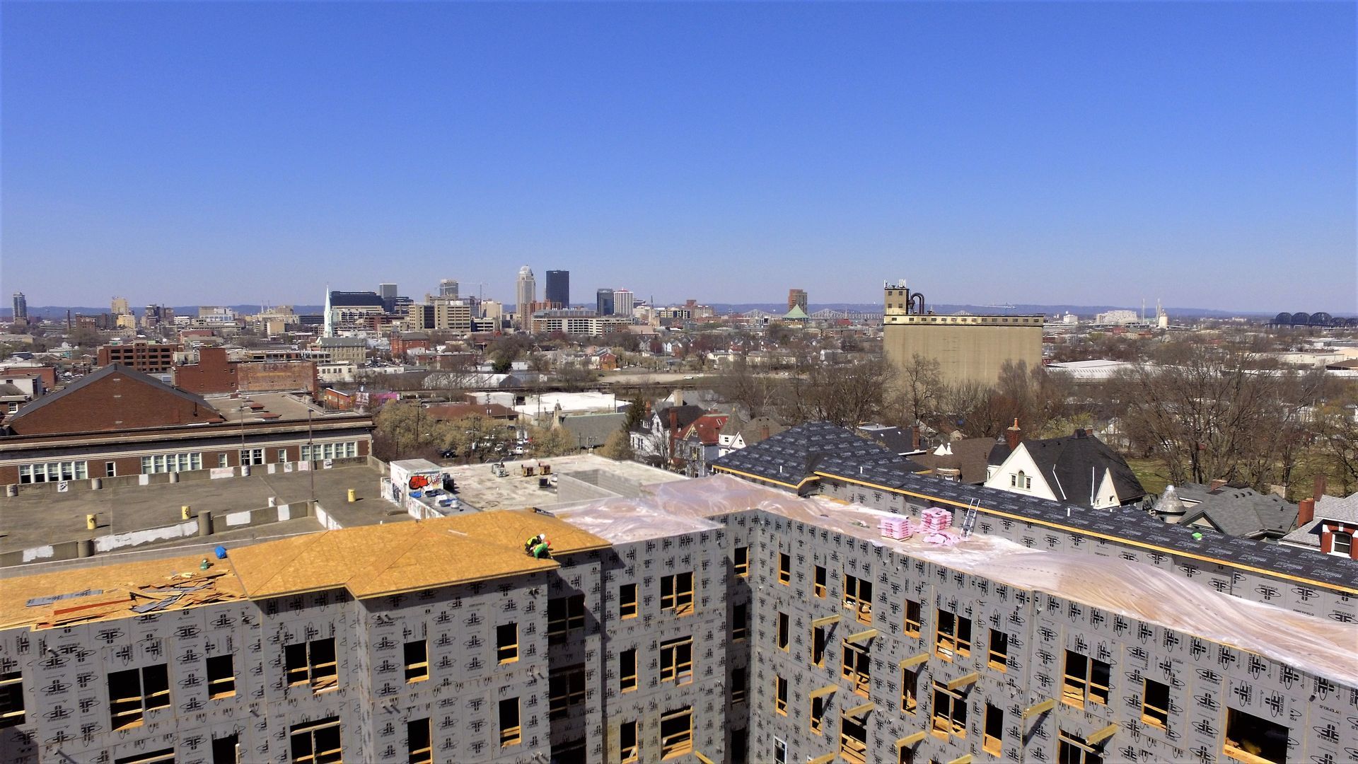 An aerial view of a building under construction with a city in the background.