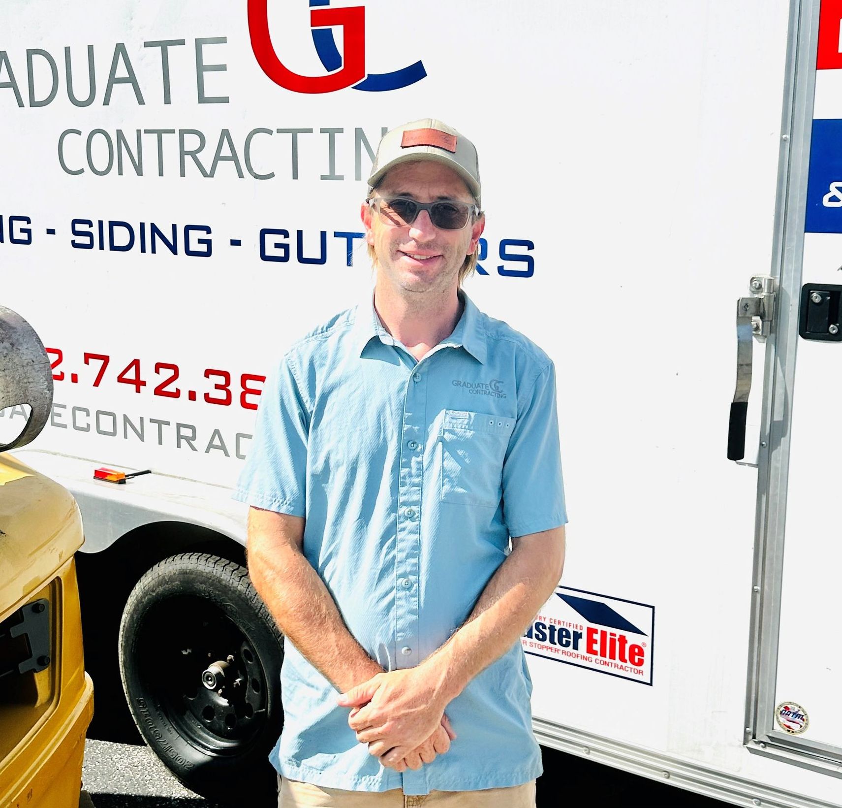 A man standing in front of a graduate contracting truck