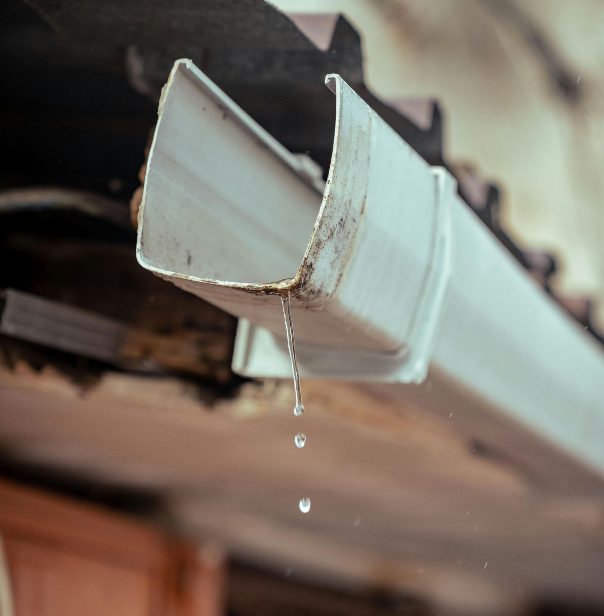 White rain gutter dripping water.
