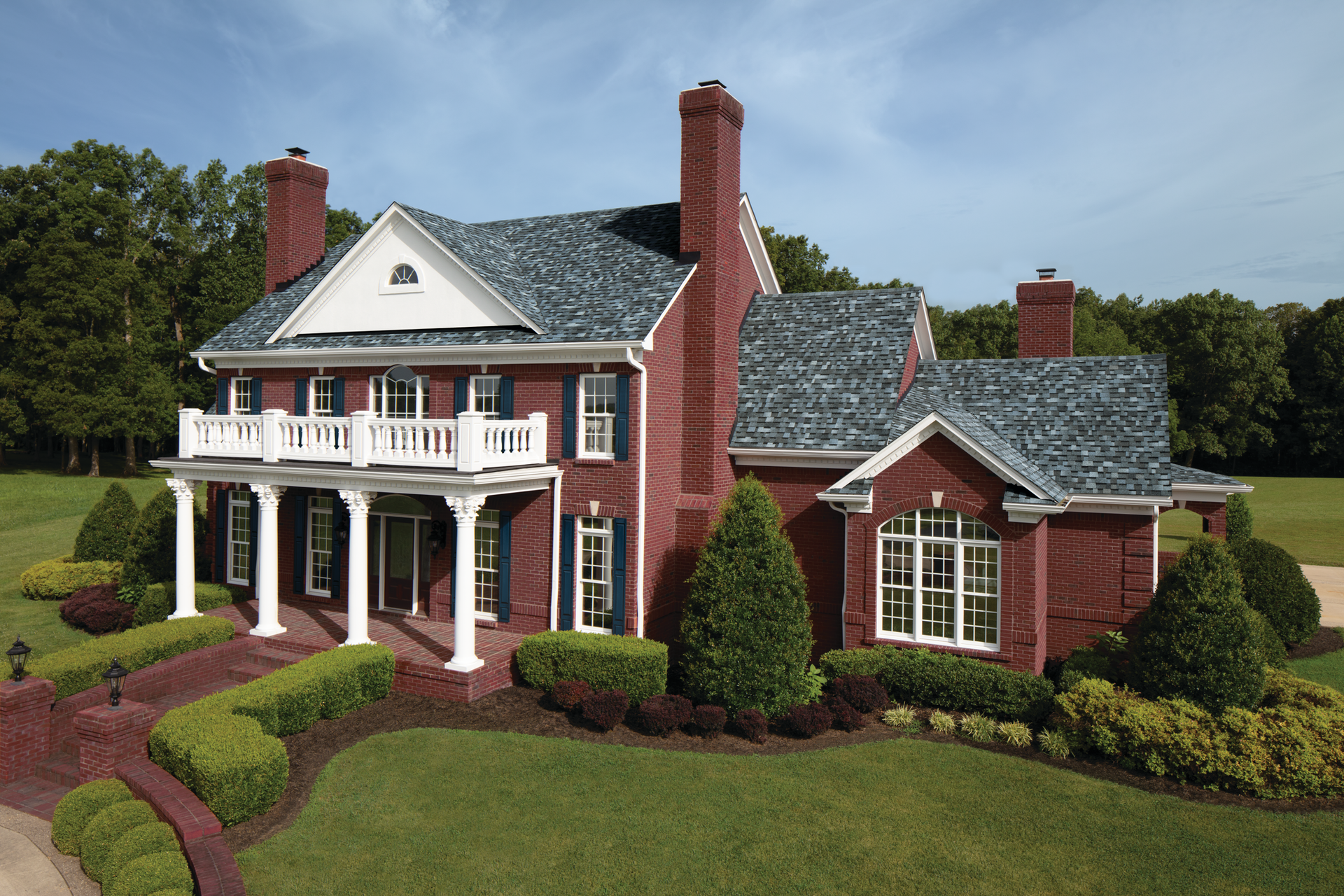 a large red brick house with a custom shingle roof