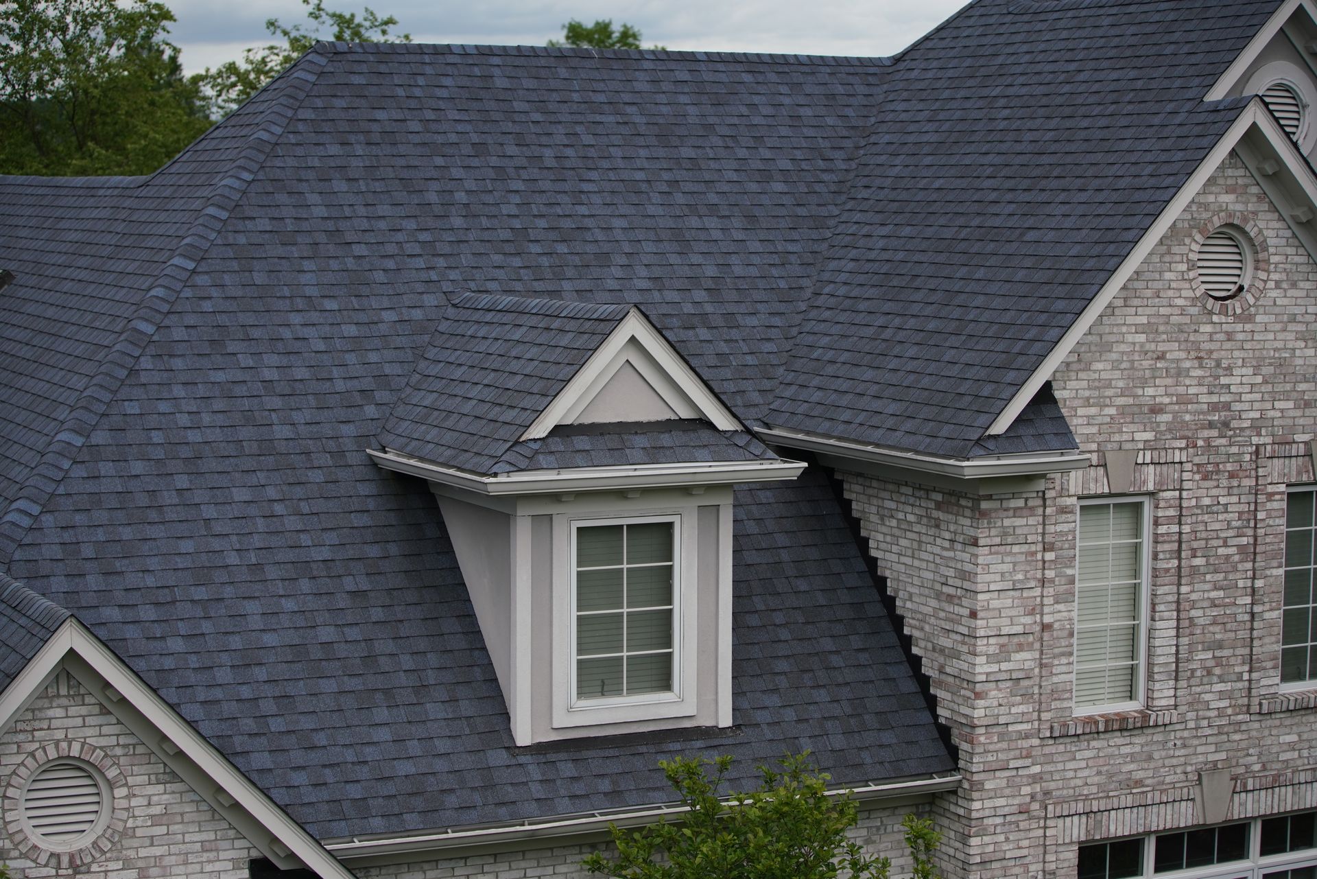 A brick house with a blue roof and a window