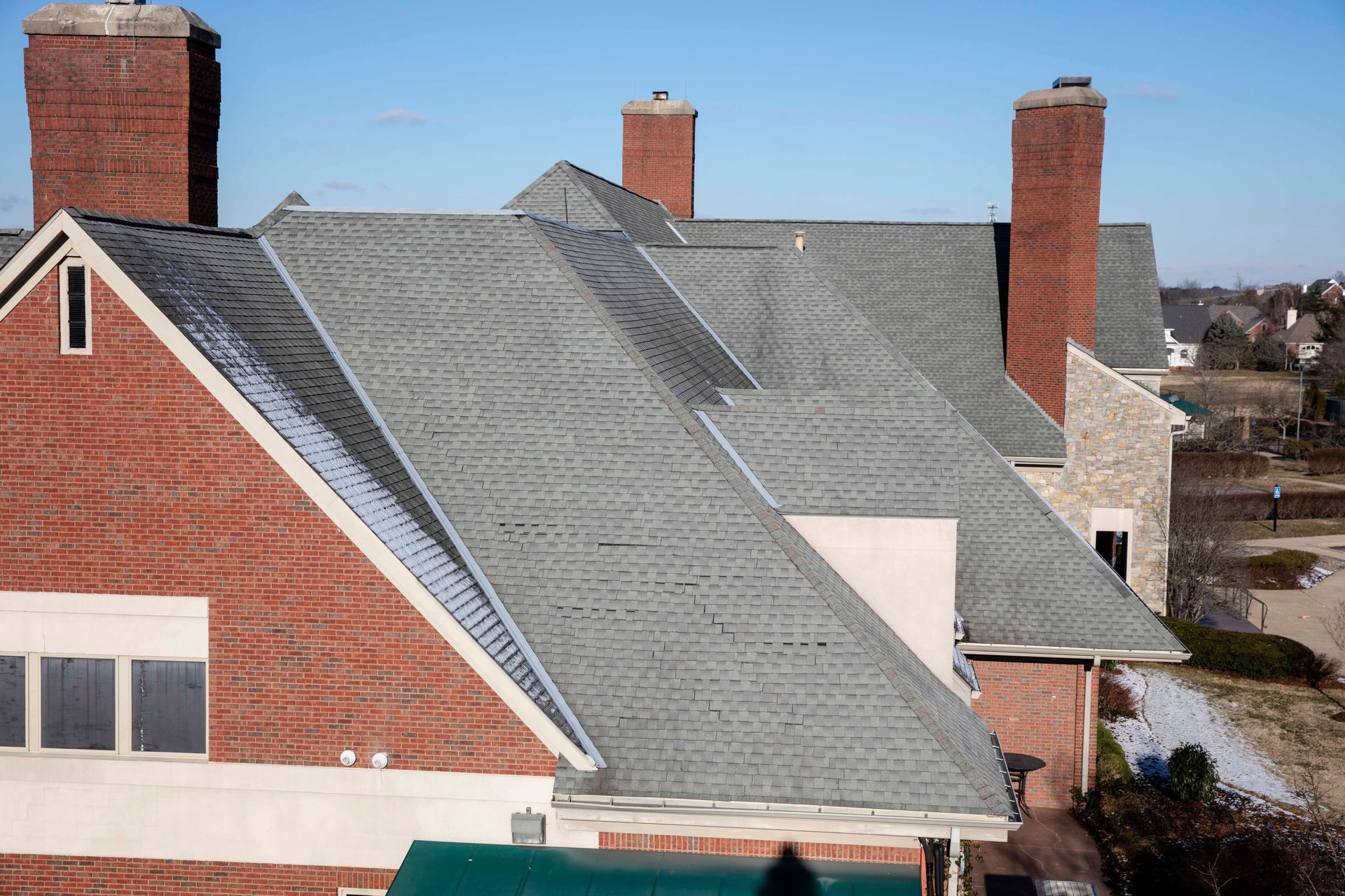 A brick building with a gray roof and chimneys