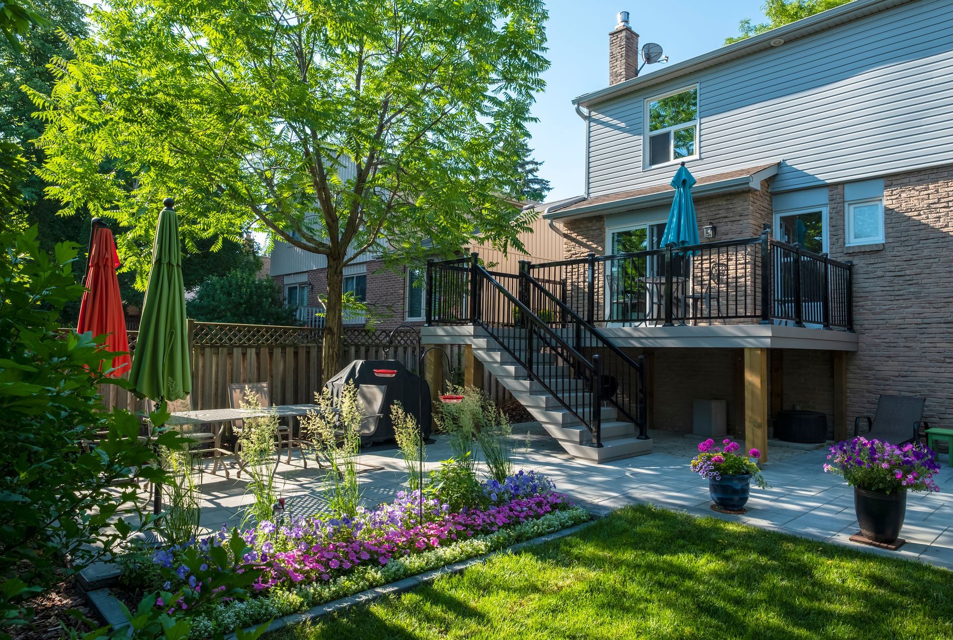 A backyard with a large deck and stairs leading up to it.