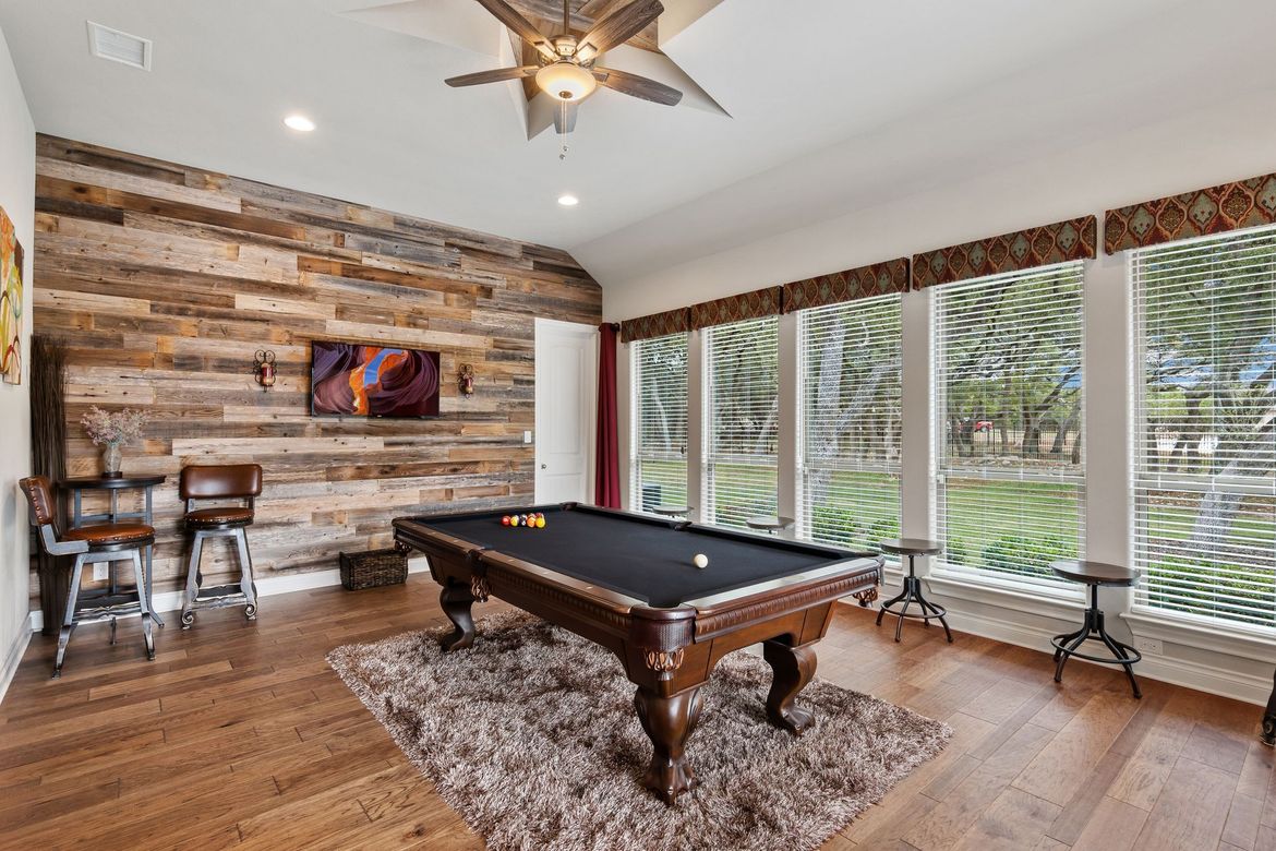 There is a pool table in the middle of the room.