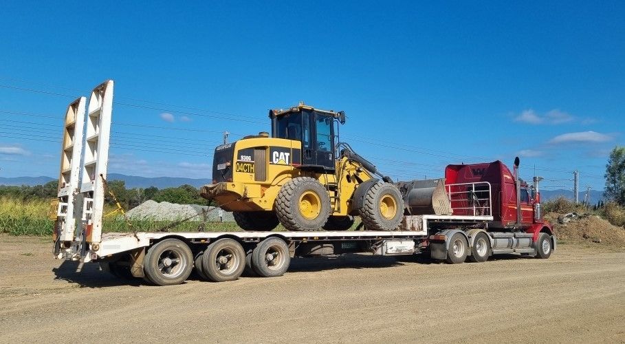 White semi-truck with two trailers loaded with gravel on dirt, parked on a sunny day — Chewies Tipper Hire & Haulage in Gracemere, QLD