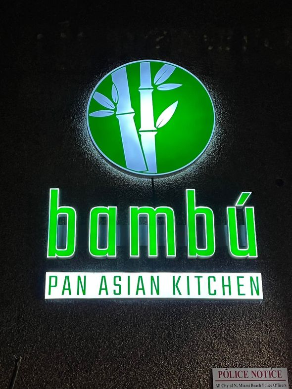BambĂș Pan Asian Kitchen sign with bamboo graphic, green and white against a dark background.
