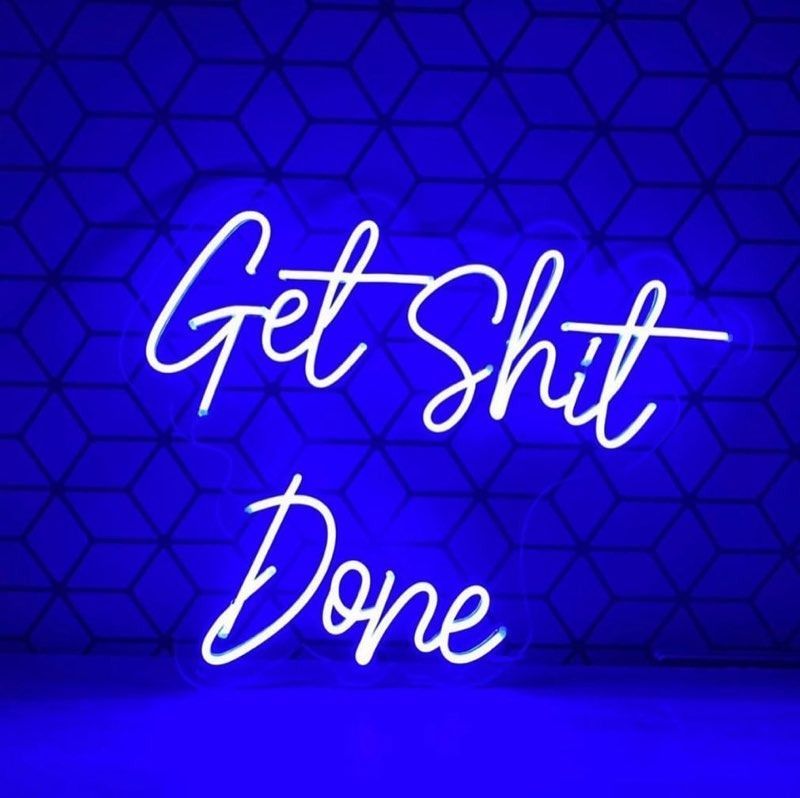 White neon sign on blue geometric background, reading 