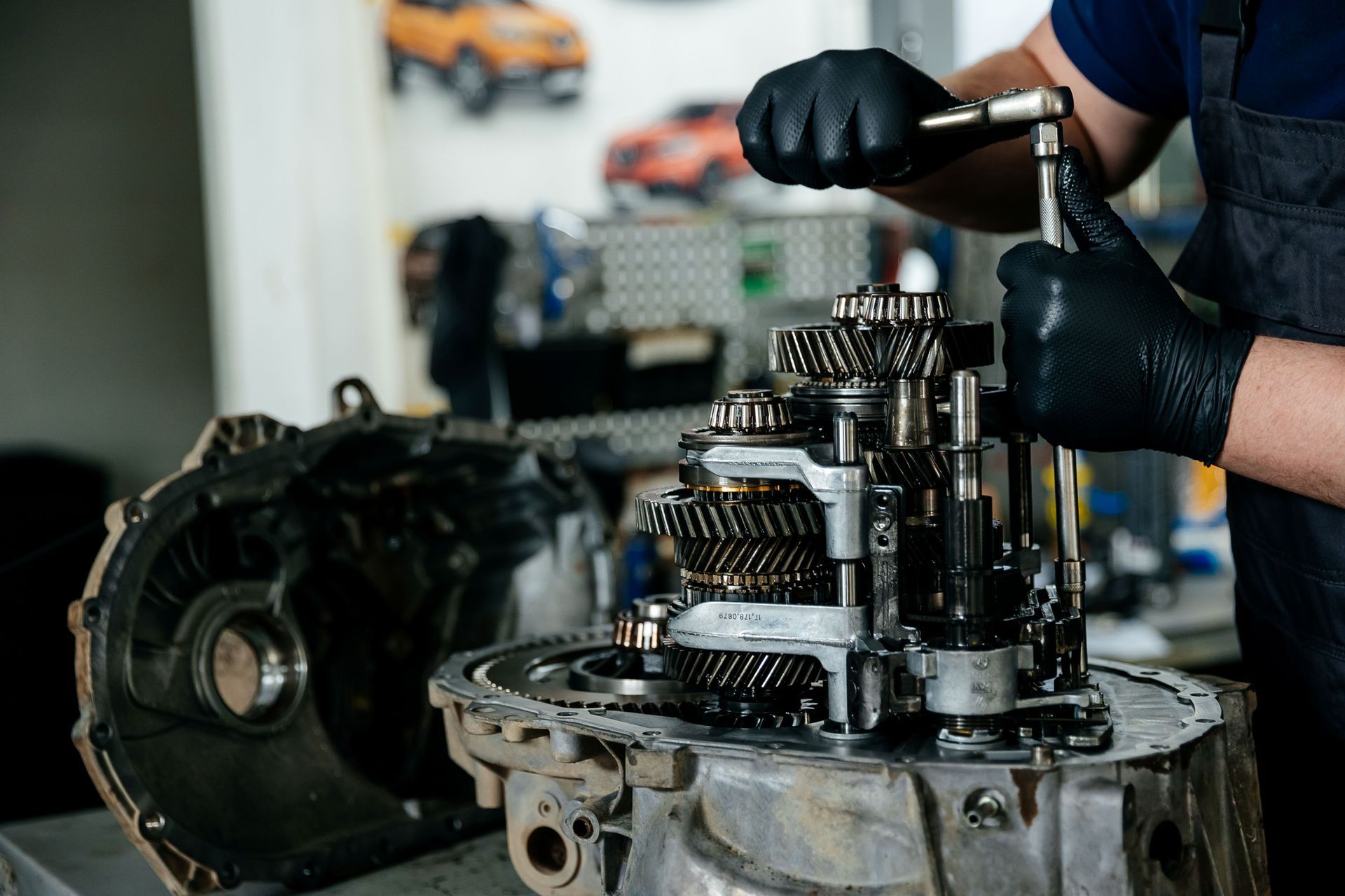 Mechanic In Black Gloves Working On A Disassembled Car Transmission — Britek Automotive in Bentley Park, QLD