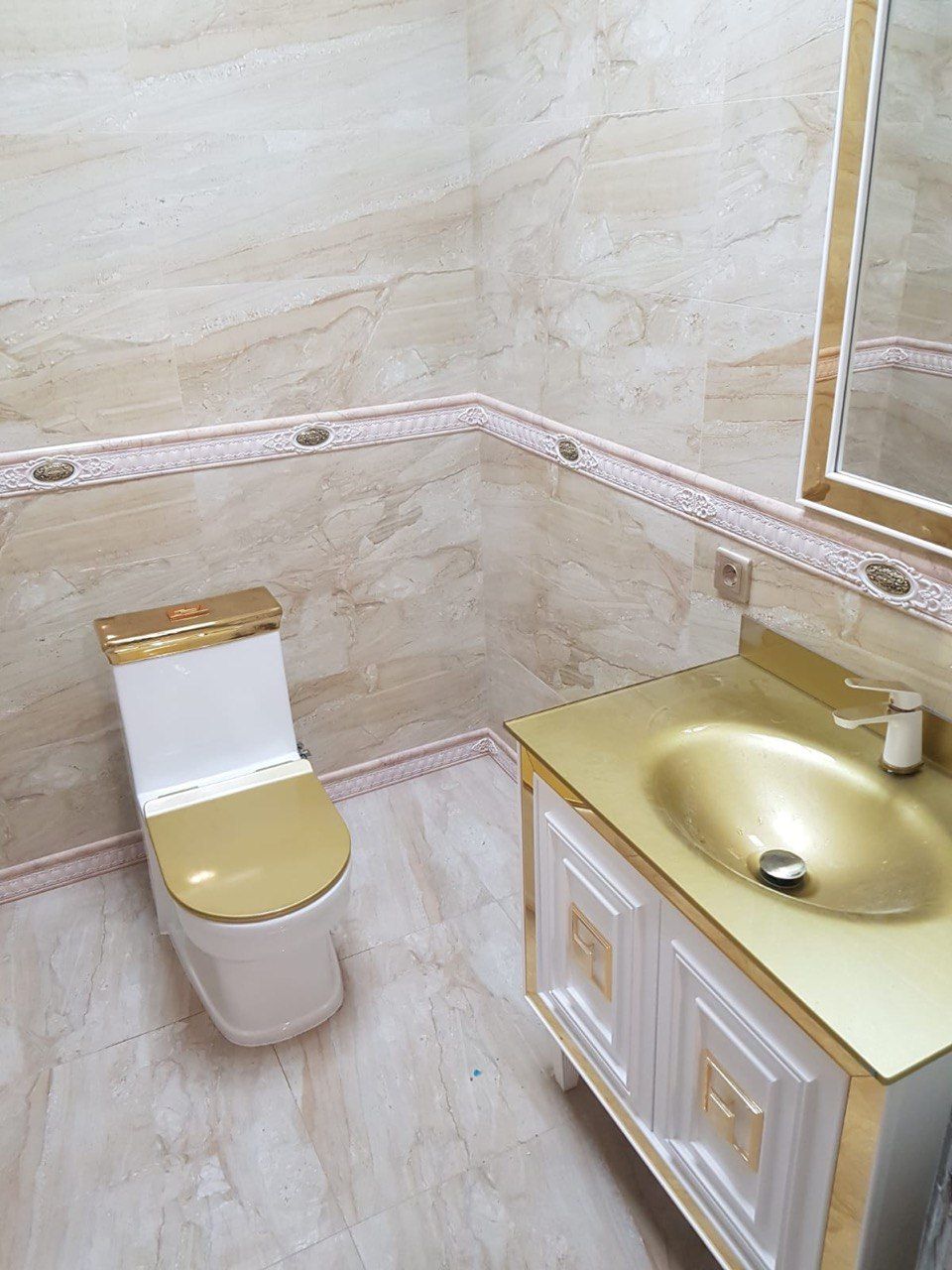 A bathroom with a toilet , sink and mirror