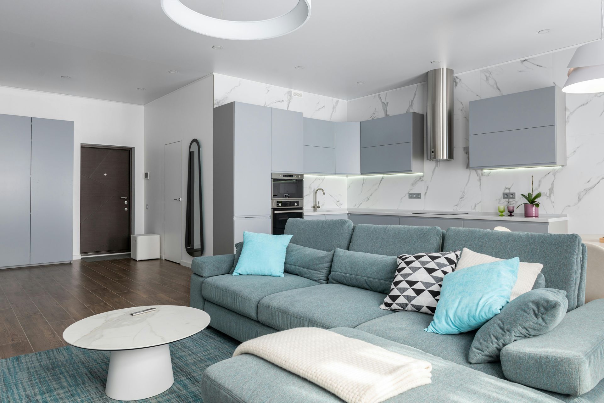 A living room with a blue couch and a white coffee table.