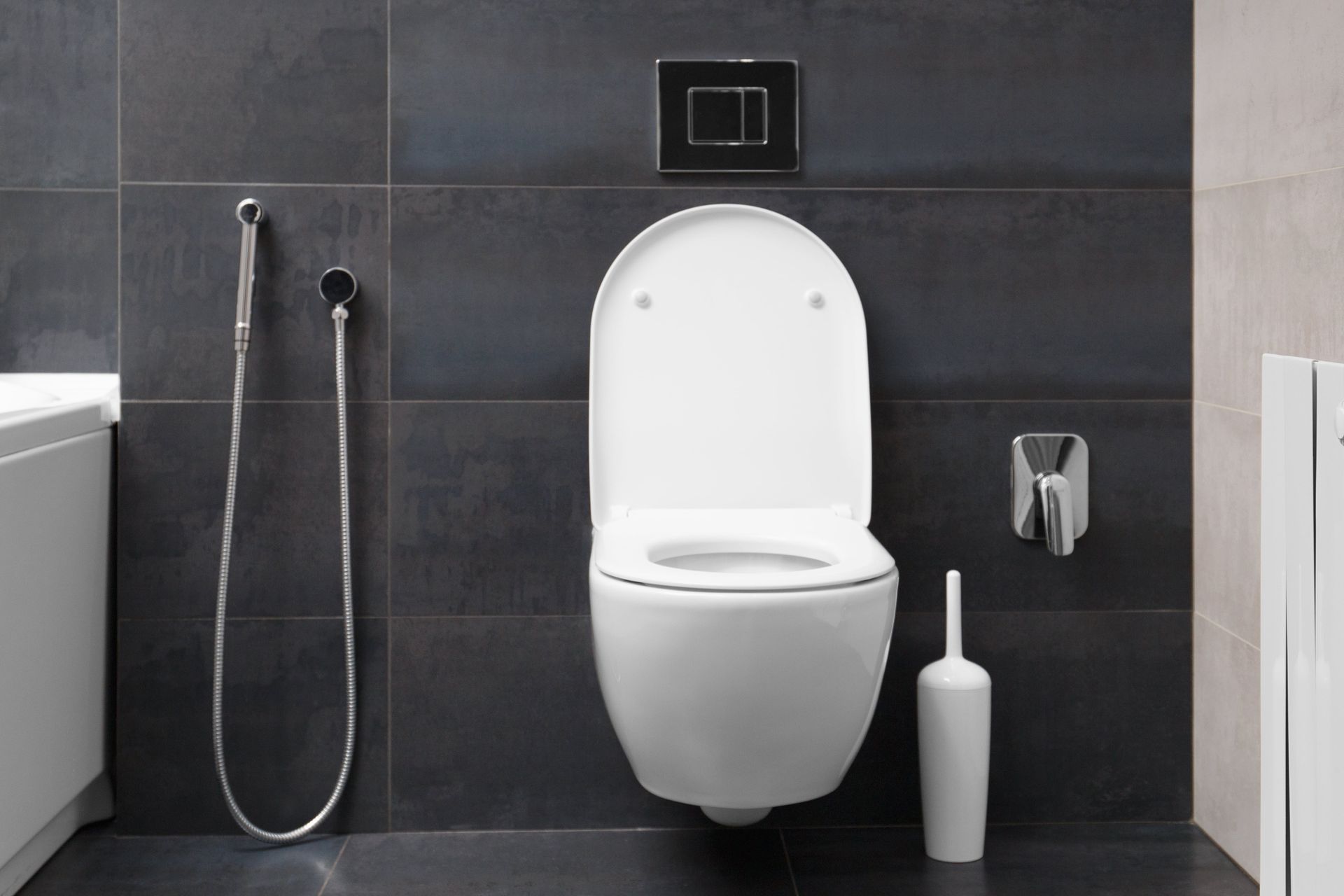 A bathroom with a toilet and a bidet attached to it